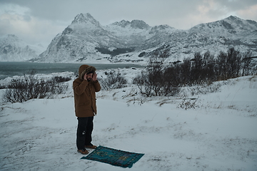 Image showing Muslim traveler praying in cold snowy winter day