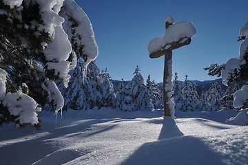 Image showing wooden cross covered with fresh snow at beautiful fresh winter morning