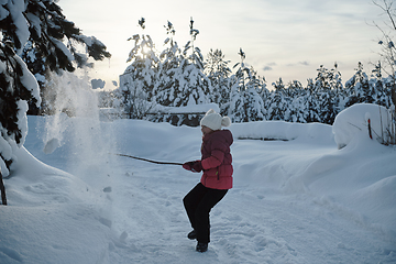 Image showing girl throwing fresh snow at beautiful sunny winter day