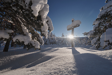 Image showing wooden cross covered with fresh snow at beautiful fresh winter morning