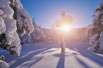Image showing wooden cross covered with fresh snow at beautiful fresh winter morning