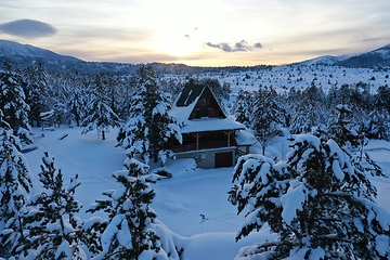 Image showing fresh snow covered trees and wooden cabin in wilderness