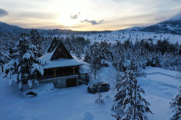 Image showing fresh snow covered trees and wooden cabin in wilderness