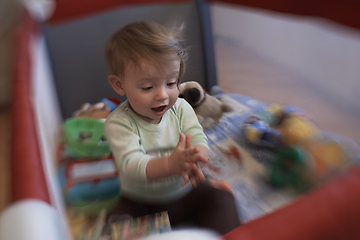 Image showing cute little baby playing in mobile bed