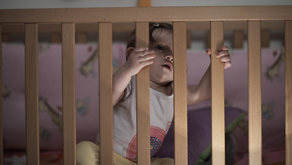 Image showing cute little one year old baby and making first steps in bed