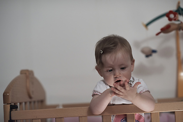 Image showing cute little one year old baby and making first steps in bed