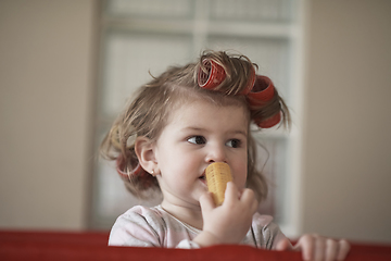 Image showing little baby girl with strange hairstyle and curlers