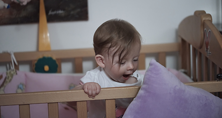 Image showing cute little one year old baby and making first steps in bed