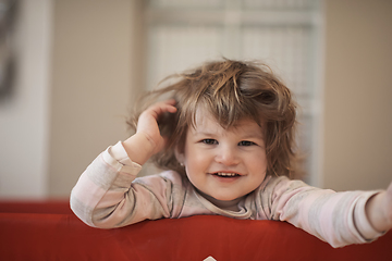 Image showing little baby girl with strange hairstyle and curlers