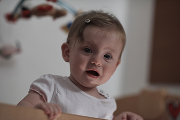 Image showing cute little one year old baby and making first steps in bed