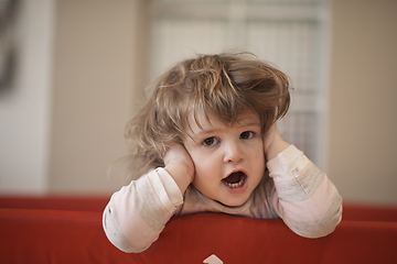 Image showing little baby girl with strange hairstyle and curlers