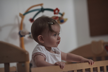 Image showing cute little one year old baby and making first steps in bed