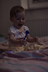 Image showing cute little one year old baby and making first steps in bed