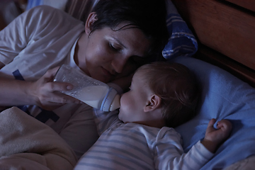 Image showing baby eating milk from bottle