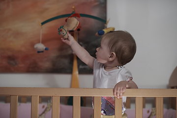 Image showing cute little one year old baby and making first steps in bed