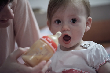 Image showing little baby drinking juice from bottle