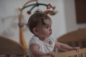 Image showing cute little one year old baby and making first steps in bed