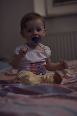 Image showing cute little one year old baby and making first steps in bed