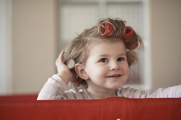 Image showing little baby girl with strange hairstyle and curlers