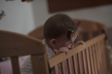 Image showing cute little one year old baby and making first steps in bed