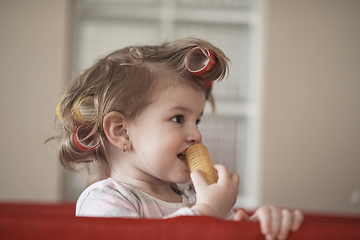 Image showing little baby girl with strange hairstyle and curlers