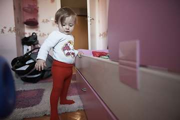 Image showing cute little one year old baby and making first steps