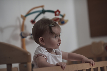 Image showing cute little one year old baby and making first steps in bed