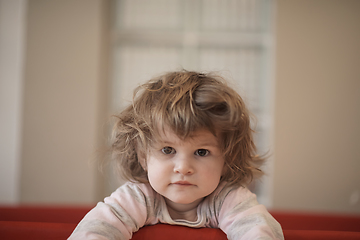 Image showing little baby girl with strange hairstyle and curlers