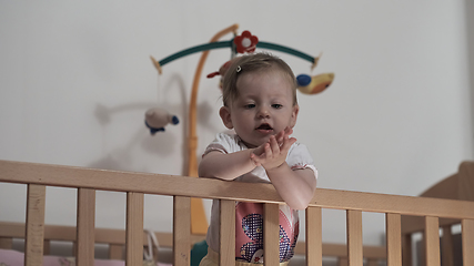 Image showing cute little one year old baby and making first steps in bed