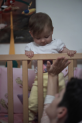 Image showing cute little one year old baby and making first steps in bed