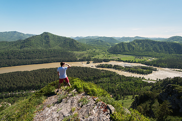 Image showing Man standing on top of cliff