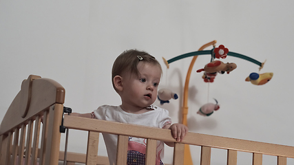 Image showing cute little one year old baby and making first steps in bed