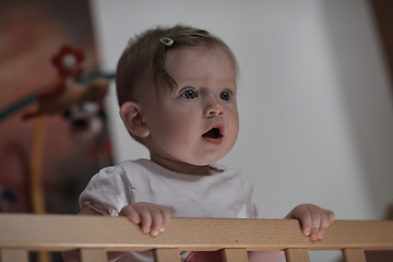 Image showing cute little one year old baby and making first steps in bed