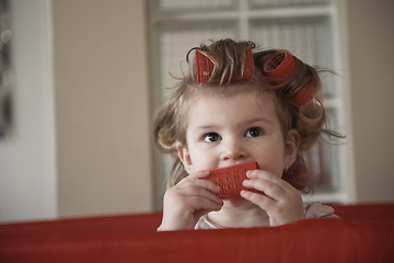 Image showing little baby girl with strange hairstyle and curlers