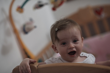 Image showing cute little one year old baby and making first steps in bed