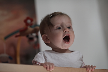 Image showing cute little one year old baby and making first steps in bed