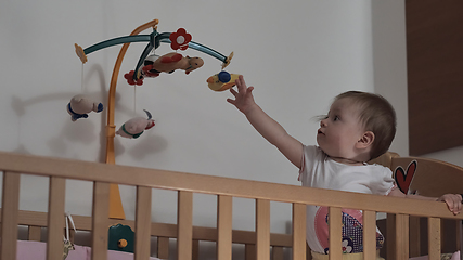 Image showing cute little one year old baby and making first steps in bed