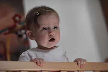 Image showing cute little one year old baby and making first steps in bed