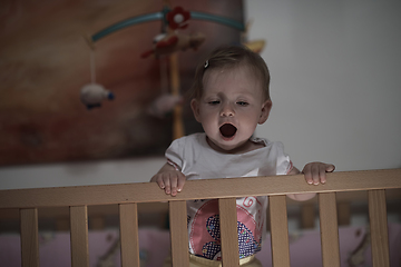 Image showing cute little one year old baby and making first steps in bed