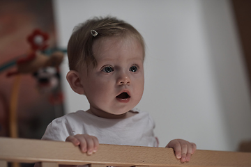 Image showing cute little one year old baby and making first steps in bed