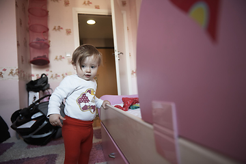 Image showing cute little one year old baby and making first steps