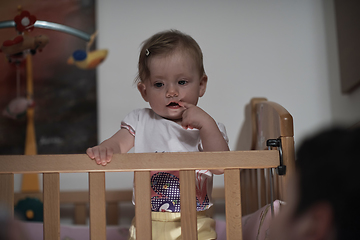 Image showing cute little one year old baby and making first steps in bed