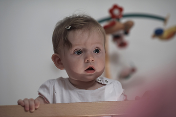 Image showing cute little one year old baby and making first steps in bed