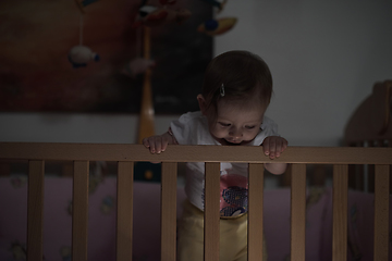 Image showing cute little one year old baby and making first steps in bed