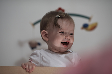 Image showing cute little one year old baby and making first steps in bed