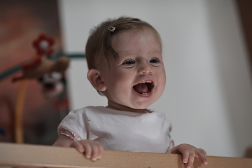 Image showing cute little one year old baby and making first steps in bed