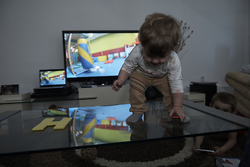 Image showing cute little one year old baby and making first steps