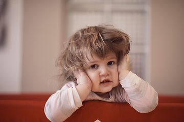 Image showing little baby girl with strange hairstyle and curlers