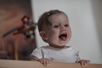 Image showing cute little one year old baby and making first steps in bed