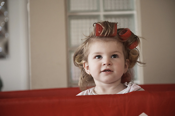 Image showing little baby girl with strange hairstyle and curlers